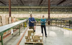 Male and female workers in a large 3PL warehouse