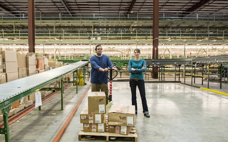 Male and female workers in a large 3PL warehouse