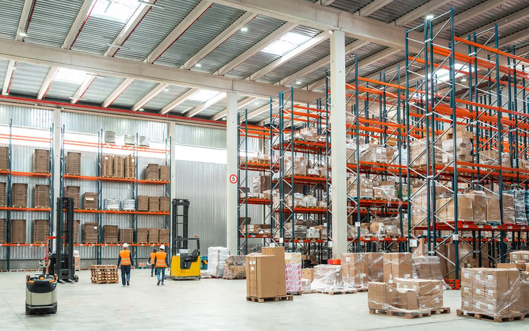 Warehouse worker managing logistics in a large distribution center for the best 3PL fulfillment services of 2025 blog