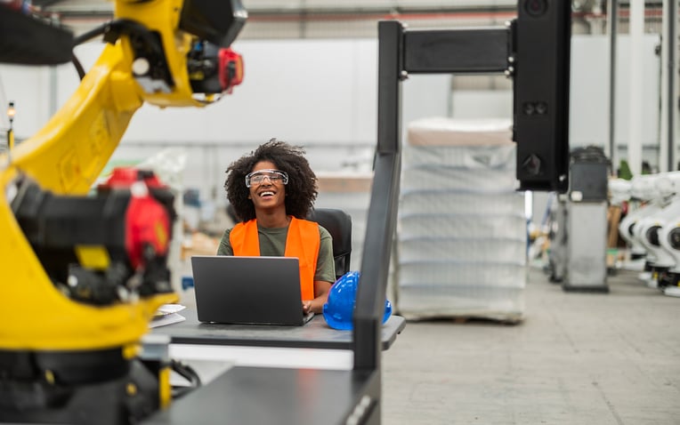 Warehouse workers use a robotic arm to sort orders more efficiently