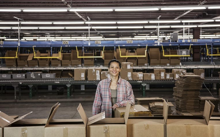 Woman in a large distribution warehouse for the 3PL fulfillment pricing guide