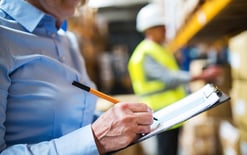 Female manager working in warehouse for inventory management metrics