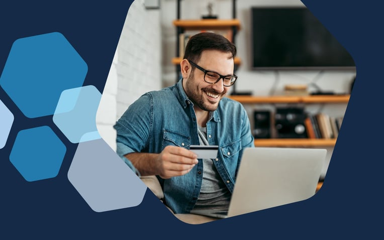 man on laptop holding credit card