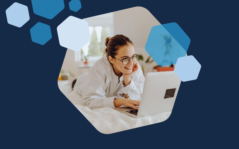 smiling woman on bed looking at computer