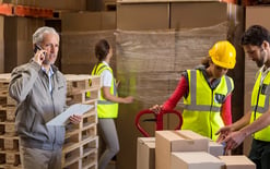 Warehouse workers use apparel returns management best practices to load a cart of returns