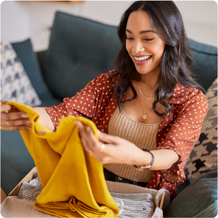 smiling woman opening kitted package from Cart.com apparel client