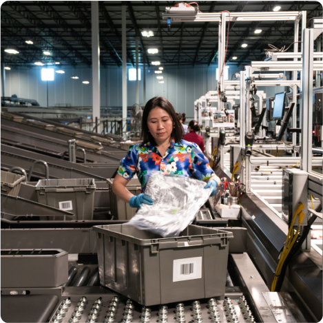 woman packing bins at an order fulfillment warehouse